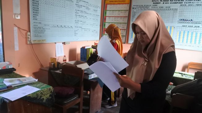Guru SDN Jugosari 03 Eri Eliyawati menyiapkan materi pelajaran di Candipuro, Lumajang, Jawa Timur.