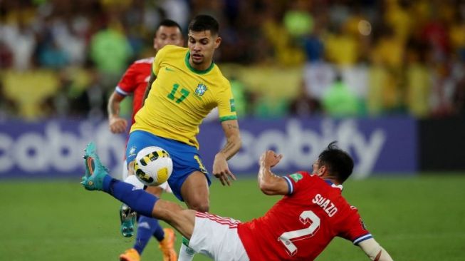 Pesepak bola Brazil Bruno Guimaraes (kiri) berebut bola dengan pesepak bola Chile Gabriel Suazo (kanan) dalam laga Kualifikasi Piala Dunia 2022 zona Amerika Selatan, di Stadion Maracana, Rio de Janeiro, Brazil, Kamis (24/3/2022). Brazil berhasil mengalahkan Chile 4-0. ANTARA FOTO/Reuters-Ricardo Moraes/hp.