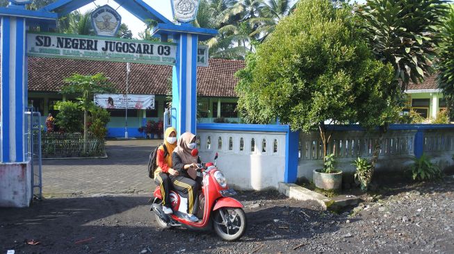 Guru SDN Jugosari 03 Eri Eliyawati dan Lilik Kusnilawati berangkat meninggalkan sekolah menuju tempat para murid yang terisolir di Candipuro, Lumajang, Jawa Timur.