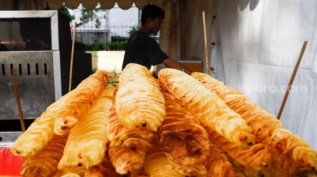 Pedagang menjual makanan saat bazar ramadhan di Monumen Pancasila Sakti, Lubang Buaya, Jakarta Timur, Minggu (24/4/2022). [Suara.com/Alfian Winanto]