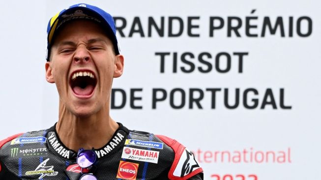 Rider Monster Energy Yamaha, Fabio Quartararo merayakan kemenangannya di MotoGP Portugal 2022 yang dihelat di Sirkuit Internasional Algarve, Portimao, Minggu (24/4/2022) malam WIB. [GABRIEL BOUYS / AFP]