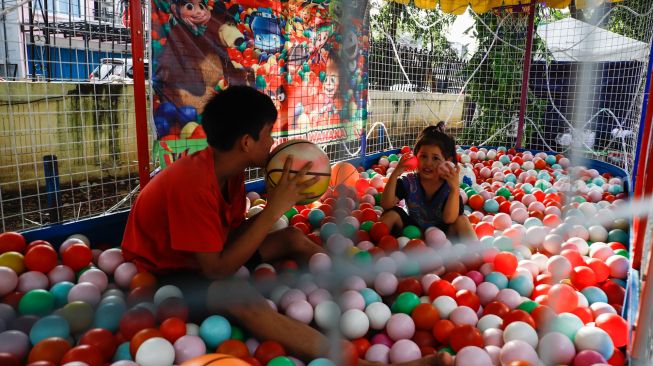 Anak-anak bermain saat bazar ramadhan di Monumen Pancasila Sakti, Lubang Buaya, Jakarta Timur, Minggu (24/4/2022). [Suara.com/Alfian Winanto]