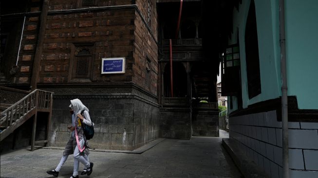 Umat Muslim berjalan pulang usai berdoa saat bulan suci Ramadhan di Masjid Khanqah Shah, Srinagar, India, Rabu (13/4/2022). [TAUSEEF MUSTAFA / AFP]
