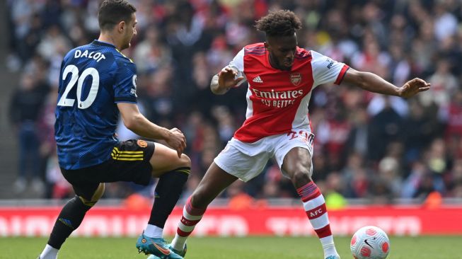 Bek Arsenal Nuno Tavares (kanan) bersaing dengan bek Manchester United Diogo Dalot (kiri) saat pertandingan sepak bola Liga Premier Inggris antara Arsenal dan Manchester United di Stadion Emirates, London, Inggris, Sabtu (23/4/2022). [Glyn KIRK / AFP )