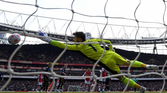 Penjaga gawang Manchester United David de Gea tidak bisa menahan tembakan jarak jauh dari pemain tengah Arsenal Granit Xhaka saat pertandingan sepak bola Liga Premier Inggris antara Arsenal dan Manchester United di Stadion Emirates, London, Inggris, Sabtu (23/4/2022). [Glyn KIRK / AFP]
