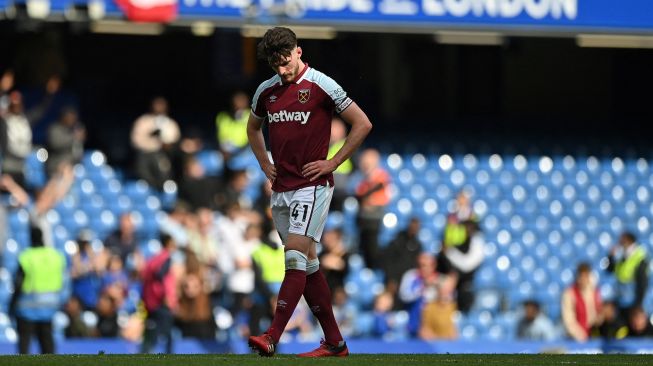 Reaksi gelandang West Ham United Declan Rice setelah pertandingan sepak bola Liga Premier Inggris antara Chelsea dan West Ham United di Stadion Stamford Bridge, London, Inggris, Minggu (24/4/2022). [JUSTIN TALLIS / AFP]
