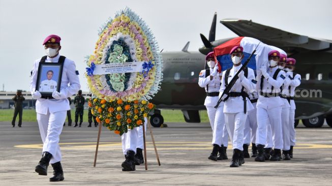 Sejumlah prajurit Marinir TNI AL mengangkat peti jenazah prajurit Korps Marinir Praka Marinir Anumerta Dwi Miftachul Achyar setibanya di Base Ops Bandara Juanda Surabaya, Jawa Timur. Minggu (24/4/2022).  [ANTARA FOTO/Serma Mar Kuwadi/MRH/foc]
