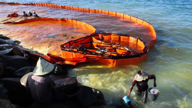 Warga mengambil minyak solar yang tumpah dari kapal penggangkut Bahan Bakar Minyak (BBM) di Pelabuhan Depot Pertamina Desa Hagu Selatan, Lhokseumawe, Aceh, Minggu (24/4). [ANTARA FOTO/Rahmad/foc]