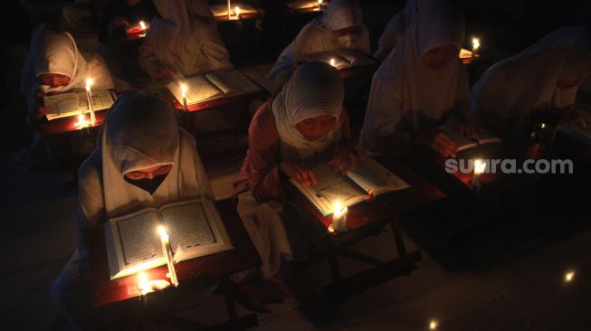 Potret Santri di Solo Khusyuk Membaca Alquran di Bawah Temaram Sentir dan Lilin Sambut Malam Lailatul Qadar