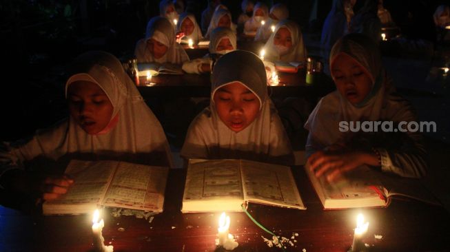 Khusyuknya Santri di Solo Membaca Alquran di Bawah Temaram Sentir dan Lilin dalam Menyambut Malam Lailatul Qadar