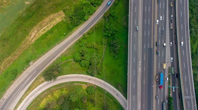 Foto udara kendaraan melaju di ruas jalan Tol saat uji coba ganjil genap di Tol Jakarta - Cikampek Karawang, Jawa Barat, Senin (25/4/2022). [ANTARA FOTO/M Ibnu Chazar/aww]