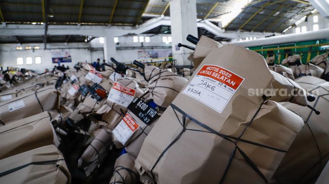 Petugas mengemas motor sebelum dikirim menggunakan kereta di Stasiun Kampung Bandan, Jakarta Utara, Selasa (26/4/2022). [Suara.com/Alfian Winanto]