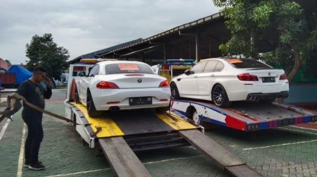 Barang bukti dua mobil BMW atas kasus robot trading Evotrade. [Humas Kejaksaan Negeri Kota Malang]