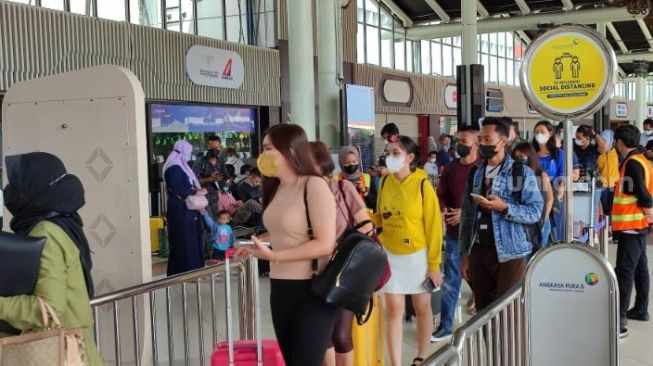 Para penumpang mengantre di pintu keberangkatan domestik Terminal 1A Bandara Soekarno-Hatta, Rabu (27/4/2022). [SuaraJakarta.id/Wivy Hikmatullah]