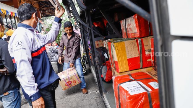 Calon penumpang menaruh barang bawaa ke bagasi bus antarkota antarprovinsi (AKAP) di Terminal Kampung Rambutan, Jakarta Timur, Rabu (27/4/2022). [Suara.com/Alfian Winanto]