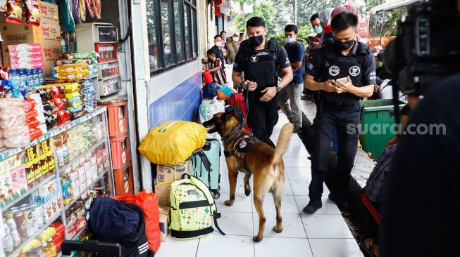 Tim K9 dari BNN melakukan pemeriksaan barang bawaan para pemudik di Terminal Kampung Rambutan, Jakarta Timur, Rabu (27/4/2022). [Suara.com/Alfian Winanto]