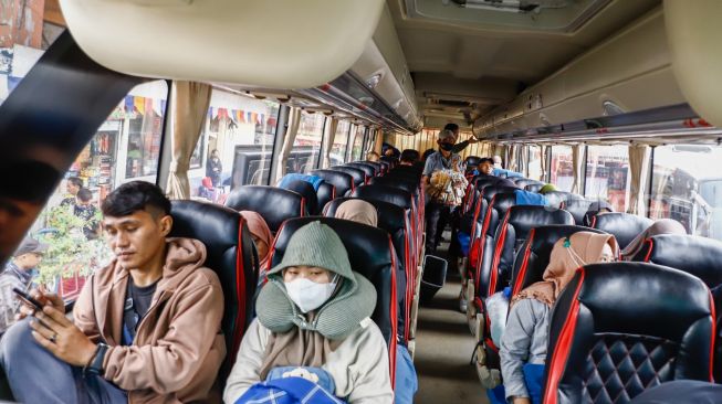 Penumpang menaiki bus antarkota antarprovinsi (AKAP) di Terminal Kampung Rambutan, Jakarta Timur, Rabu (27/4/2022). [Suara.com/Alfian Winanto]