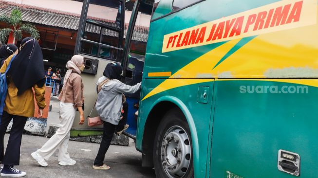 Calon penumpang menaiki bus antarkota antarprovinsi (AKAP) di Terminal Kampung Rambutan, Jakarta Timur, Rabu (27/4/2022). [Suara.com/Alfian Winanto]