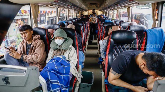 Penumpang menaiki bus antarkota antarprovinsi (AKAP) di Terminal Kampung Rambutan, Jakarta Timur, Rabu (27/4/2022). [Suara.com/Alfian Winanto]