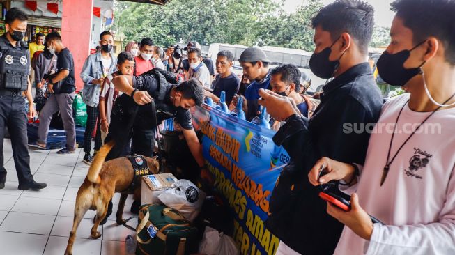 Tim K9 dari BNN melakukan pemeriksaan barang bawaan para pemudik di Terminal Kampung Rambutan, Jakarta Timur, Rabu (27/4/2022). [Suara.com/Alfian Winanto]