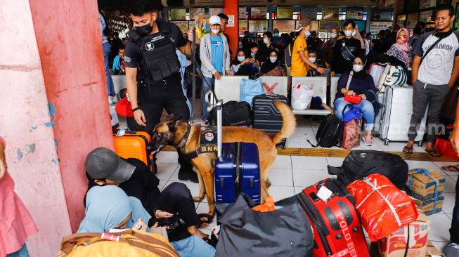 Tim K9 dari BNN melakukan pemeriksaan barang bawaan para pemudik di Terminal Kampung Rambutan, Jakarta Timur, Rabu (27/4/2022). [Suara.com/Alfian Winanto]