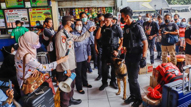 Tim K9 dari BNN melakukan pemeriksaan barang bawaan para pemudik di Terminal Kampung Rambutan, Jakarta Timur, Rabu (27/4/2022). [Suara.com/Alfian Winanto]