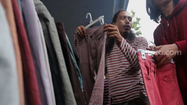 Calon pembeli memilih pakaian bekas layak pakai (thrifting) yang dijual di Pasar Kebayoran Lama, Jakarta, Kamis (28/4/2022). [Suara.com/Angga Budhiyanto]