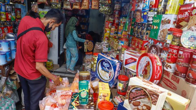 Pembeli memilih kue kering di salah satu toko kue kering di kawasan Ciracas, Jakarta Timur, Kamis (28/4/2022). [Suara.com/Alfian Winanto]