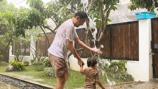 Bapak yang Asik, 5 Potret Hanung Bramantyo Ajak Putra Bungsunya Mandi Hujan