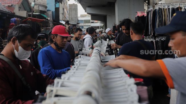 Calon pembeli memilih pakaian bekas layak pakai (thrifting) yang dijual di Pasar Kebayoran Lama, Jakarta, Kamis (28/4/2022). [Suara.com/Angga Budhiyanto]