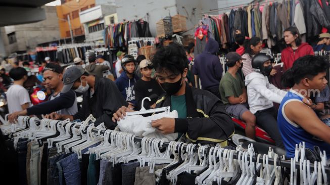 Calon pembeli memilih pakaian bekas layak pakai (thrifting) yang dijual di Pasar Kebayoran Lama, Jakarta, Kamis (28/4/2022). [Suara.com/Angga Budhiyanto]