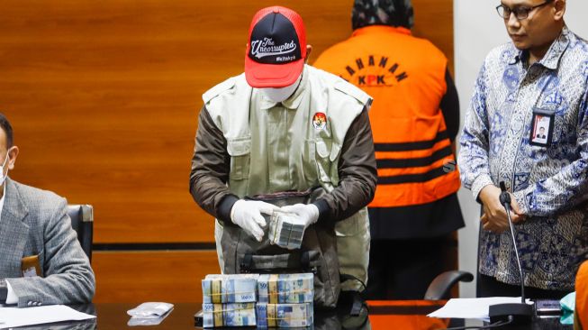 Penyidik menunjukkan barang bukti sejumlah  uang saat konferensi pers terkait Operasi Tangkap Tangan (OTT) kasus korupsi Bupati Bogor Ade Yasin di Gedung KPK, Jakarta Selatan, Kamis (28/4/2022). [Suara.com/Alfian Winanto]