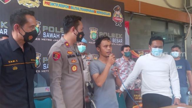 Ray Prama Abdullah (27), anggota PPSU Kelurahan Mangga Dua Selatan, Jakarta Pusat, yang kedapatan membuat laporan palsu dengan berbohong jadi korban begal dalam ungkap kasus di Polsek Sawah Besar, Jumat (29/4/2022). [Suara.com/Yosea Arga Pramudita]