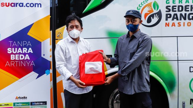 Pemimpin Redaksi Suara.com Suwarjono  memberikan bingkisan kepada warga saat aksi kemanusiaan di Kawasan Cipete Utara, Jakarta Selatan, Jumat (29/4/2022). [Suara.com/Alfian Winanto]