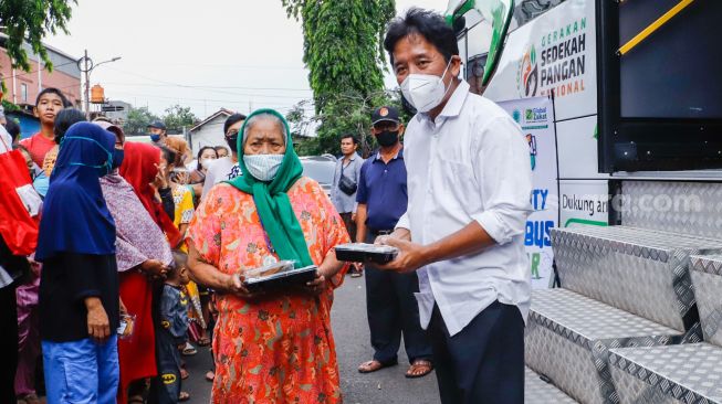 Pemimpin Redaksi Suara.com Suwarjono  memberikan bingkisan kepada warga saat aksi kemanusiaan di Kawasan Cipete Utara, Jakarta Selatan, Jumat (29/4/2022). [Suara.com/Alfian Winanto]