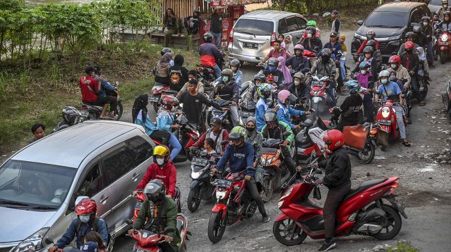 Pengendara sepeda motor melintas di jalur alternatif di Karawang, Jawa Barat, Jumat (29/4/2022).  ANTARA FOTO/Muhammad Adimaja
