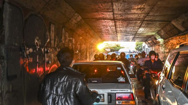 Pengendara sepeda motor melintas di jalur alternatif di Karawang, Jawa Barat, Jumat (29/4/2022).  ANTARA FOTO/Muhammad Adimaja
