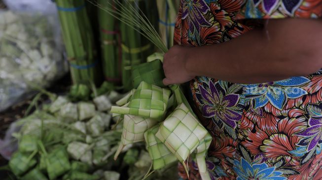 Calon pembeli memilih kulit ketupat yang dijual di Pasar Palmerah, Jakarta, Sabtu (30/4/2022). [Suara.com/Angga Budhiyanto]