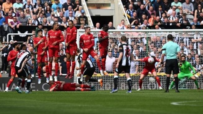 Pemain Liverpool memblok bola tendangan bebas pemain Newcastle United dalam pertandingan Liga Inggris di St. James Park, Sabtu (30/4/2022). [AFP]