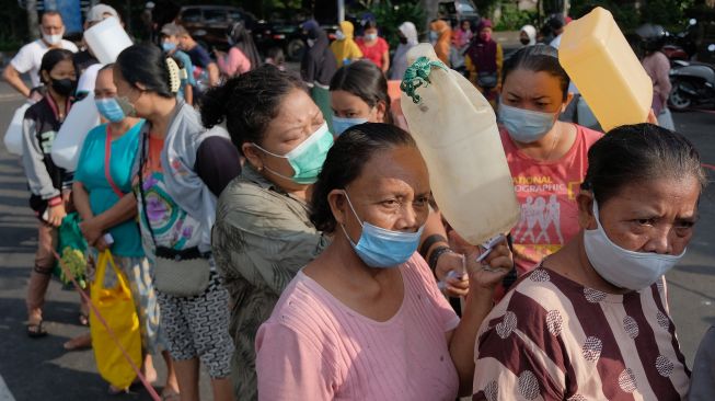 Warga antre membeli minyak goreng curah pada Gebyar 2 Ton Minyak Goreng Curah di Terminal Tegal, Denpasar, Bali, Sabtu (30/4/2022).  ANTARA FOTO/Nyoman Hendra Wibowo