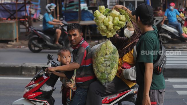 Pedagang kulit ketupat melayani pembeli di Pasar Palmerah, Jakarta, Sabtu (30/4/2022). [Suara.com/Angga Budhiyanto]