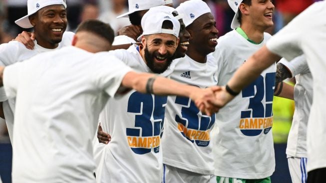 Pemain depan Real Madrid Karim Benzema (tengah) dan rekan-rekan setimnya berselebrasi setelah menjadi juara Liga Spanyol pada akhir pertandingan sepak bola Liga Spanyol antara Real Madrid dan Espanyol di Stadion Santiago Bernabeu, Madrid, Spanyol, Sabtu (30/4/2022). [Gabriel BOUYS / AFP]
