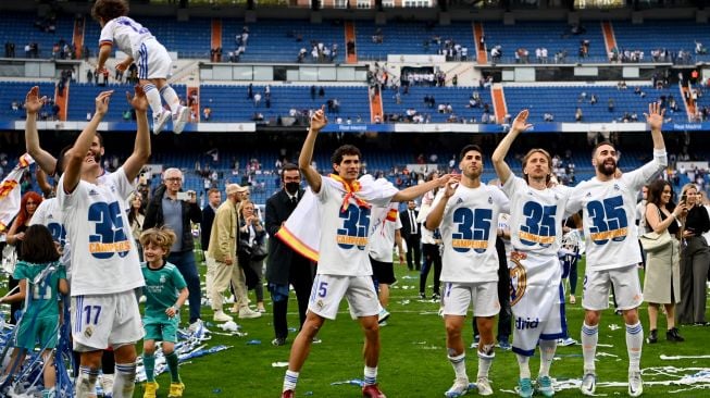 Para pemain Real Madrid berselebrasi setelah menjadi juara Liga Spanyol pada akhir pertandingan sepak bola Liga Spanyol antara Real Madrid dan Espanyol di Stadion Santiago Bernabeu, Madrid, Spanyol, Sabtu (30/4/2022). [Gabriel BOUYS / AFP]