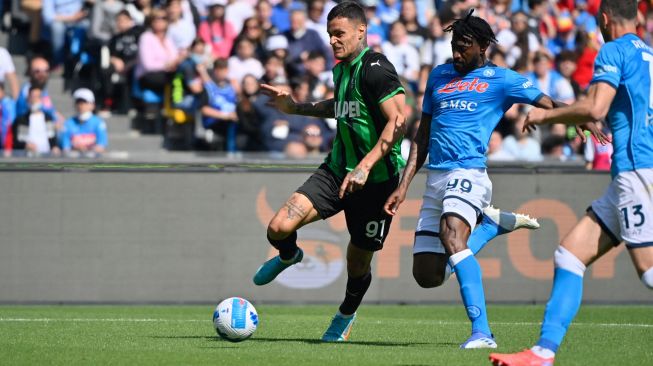 Pemain depan Sassuolo Gianluca Scamacca (kiri) berebut bola dengan gelandang Napoli Andre Zambo Anguissa (kedua kanan) saat pertandingan sepak bola Serie A Liga Italia antara Napoli vs Sassuolo di stadion Diego Armando Maradona, Naples, Italia, Sabtu (30/4/2022). [Alberto PIZZOLI / AFP]