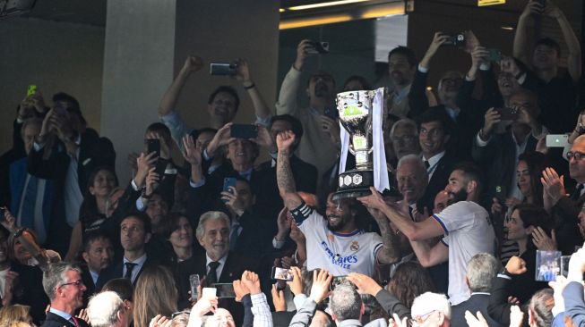 Bek Real Madrid Marcelo dan pemain depan Real Madrid Karim Benzema mengangkat trofi Piala Liga Spanyol pada akhir pertandingan sepak bola Liga Spanyol antara Real Madrid dan Espanyol di Stadion Santiago Bernabeu, Madrid, Spanyol, Sabtu (30/4/2022). [Gabriel BOUYS / AFP]