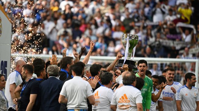 Para pemain Real Madrid selebrasi dengan trofi Piala Liga Spanyol pada akhir pertandingan sepak bola Liga Spanyol antara Real Madrid dan Espanyol di Stadion Santiago Bernabeu, Madrid, Spanyol, Sabtu (30/4/2022). [Gabriel BOUYS / AFP]