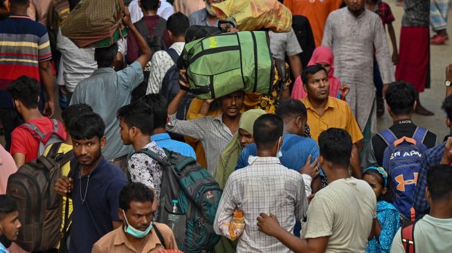 Orang-orang naik kapal feri untuk melakukan perjalanan mudik ke tempat asal mereka untuk merayakan Idul Fitri di Dhaka, Bangladesh, Sabtu (30/4/2022). [Munir uz Zaman / AFP]
