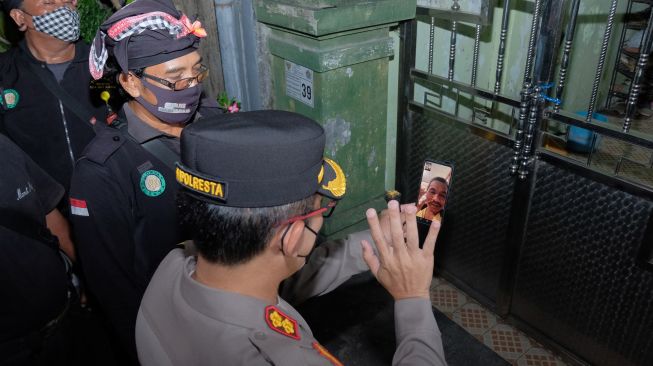 Kapolresta Denpasar AKBP Bambang Yugo Pamungkas (kanan) melakukan telepon video dengan pemilik rumah yang mudik saat patroli di Denpasar, Bali, Sabtu (30/4/2022). [ANTARA FOTO/Nyoman Hendra Wibowo/hp]