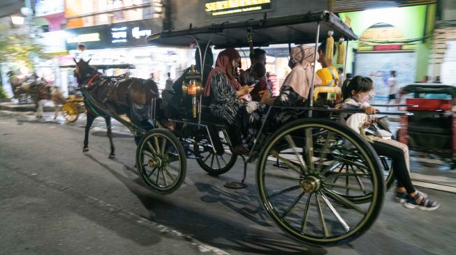 Wisatawan naik andong saat Car Free Night di Malioboro, Danurejan, Yogyakarta, Sabtu (30/4/2022). [ANTARA FOTO/Hendra Nurdiyansyah/hp.]
