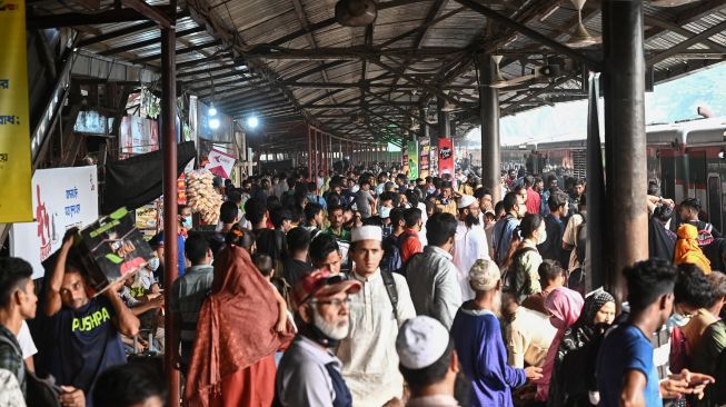 Orang-orang naik kapal feri untuk melakukan perjalanan mudik ke tempat asal mereka untuk merayakan Idul Fitri di Dhaka, Bangladesh, Sabtu (30/4/2022). [Munir uz Zaman / AFP]
